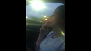 Gorgeous older smoking cigarettes while in car